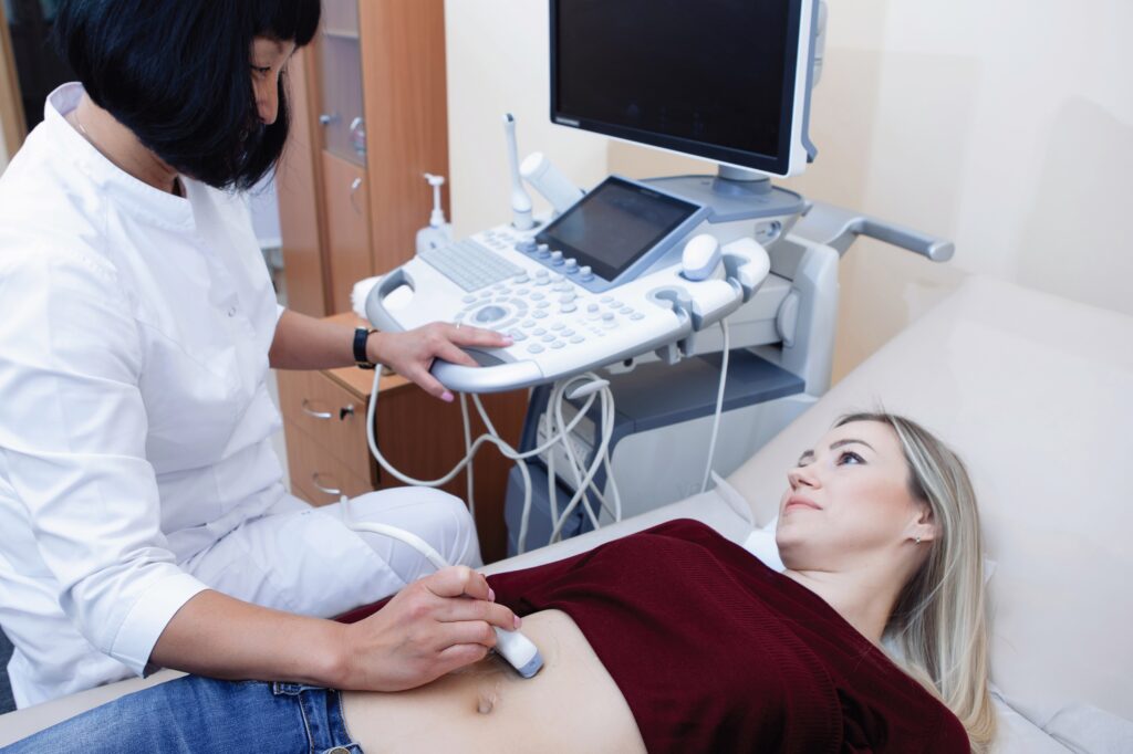 Pregnant woman undergoing an ultrasound with a physician