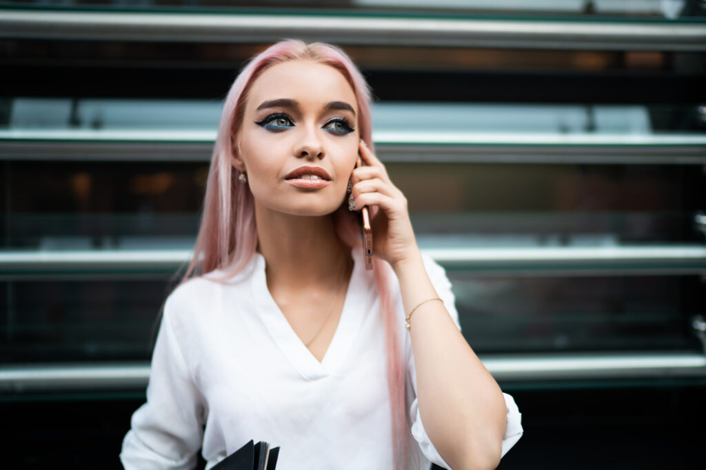 Woman with pink hair on her cell phone