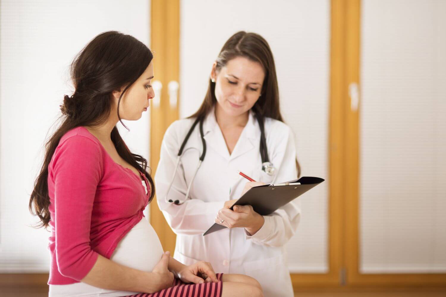pregnant woman consulting with a doctor