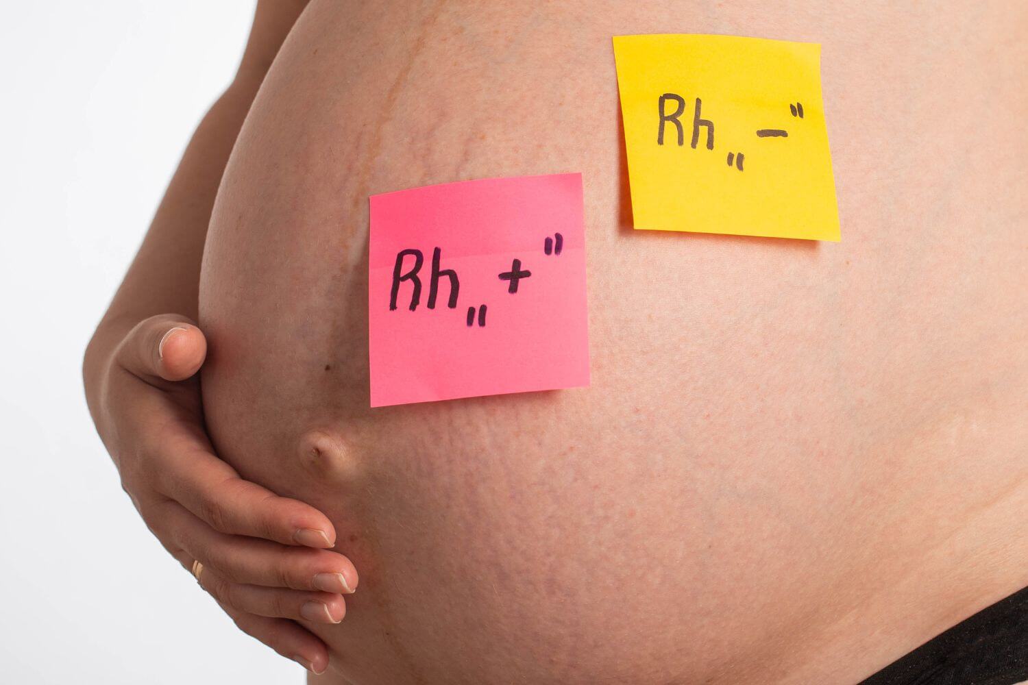 Stickers on the belly of a pregnant girl with inscriptions negative and positive Rh factor. Rh factor compatibility concept, Rh conflict.