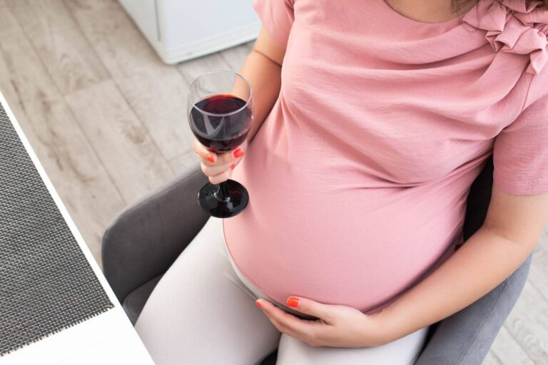 Pregnant woman holding a glass of wine