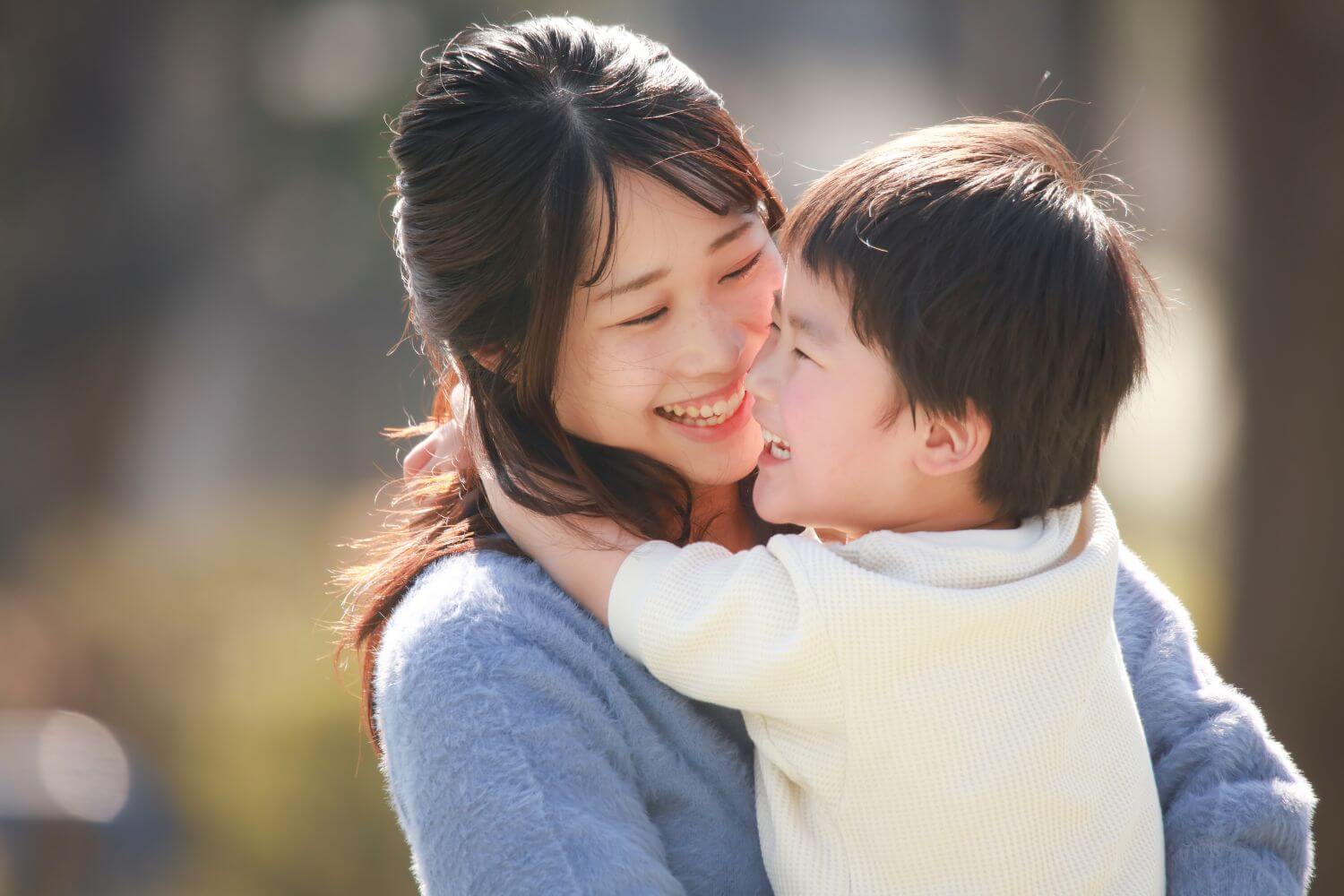 Mother embracing her son as they both smile