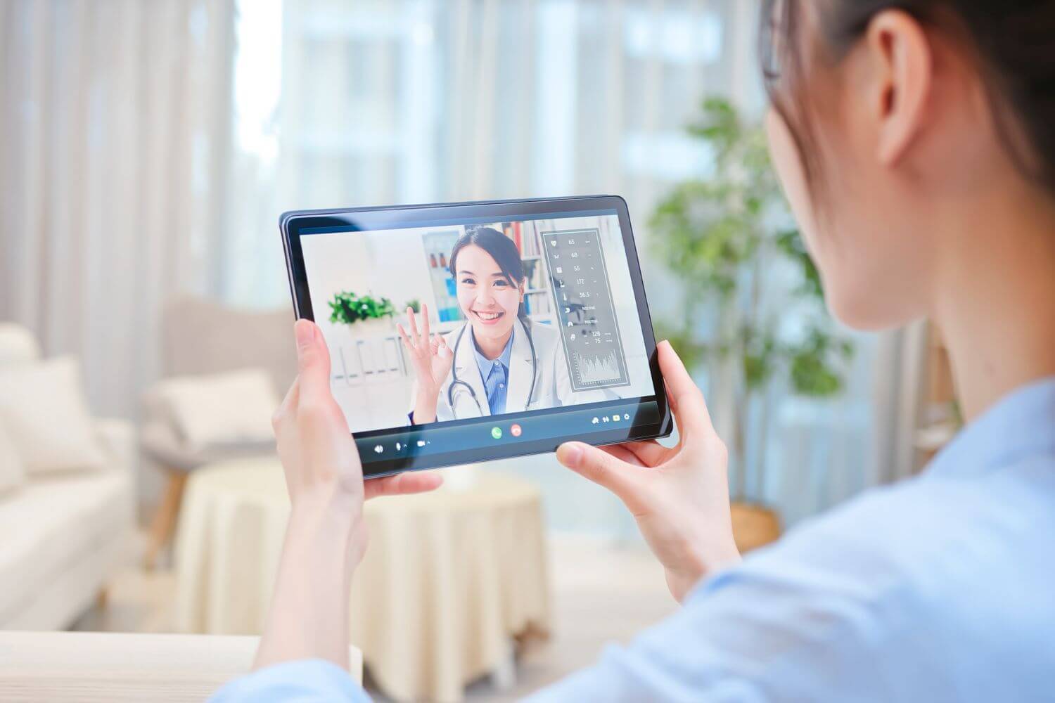 A woman holding a tablet during a telemedicine visit with her doctor