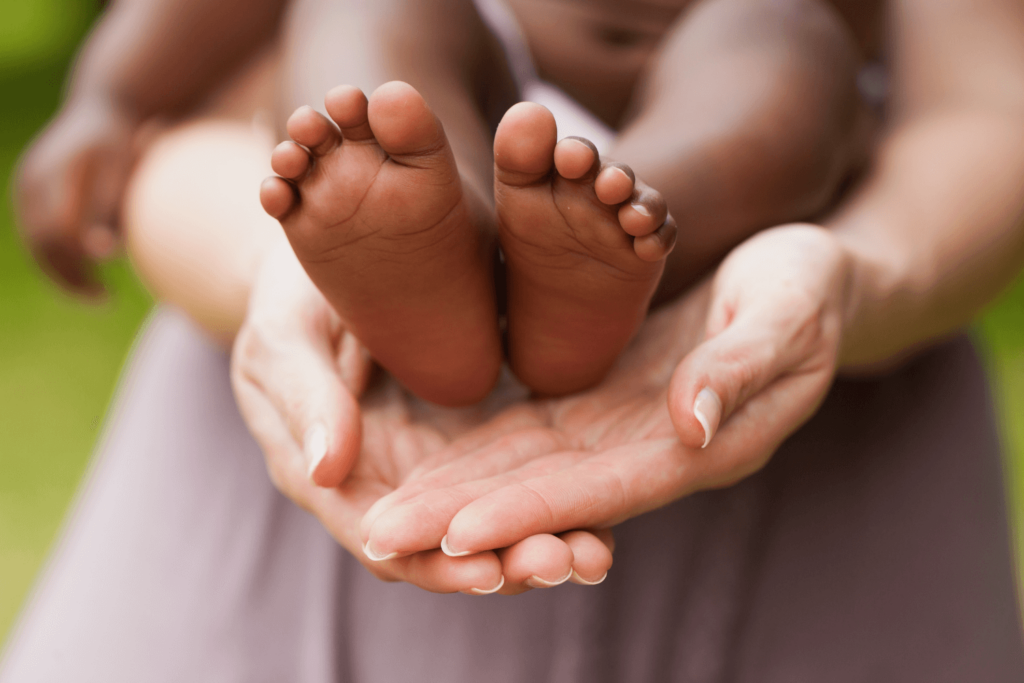 A mothers palms holding babies feet