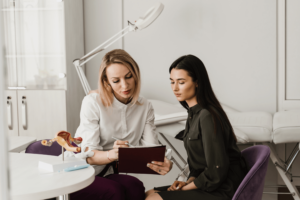 An OBGYN is reviewing medical information with a woman sitting next to her