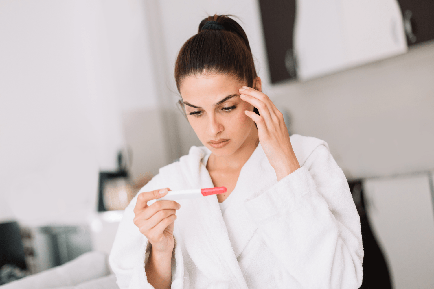 Anxious woman staring at a pregnancy test