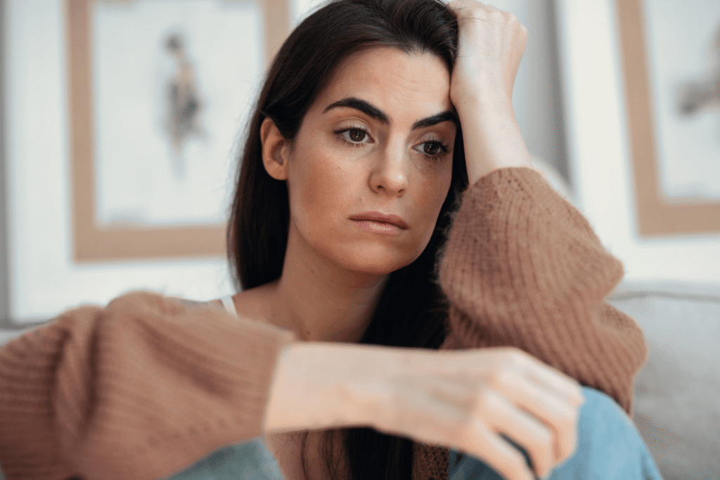 Depressed woman holding her head with her hand staring into the distance