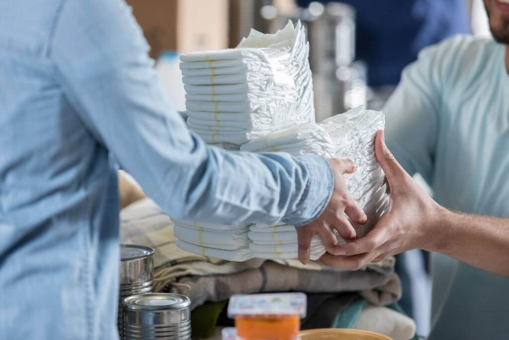 Woman giving a stack of baby diapers to a man