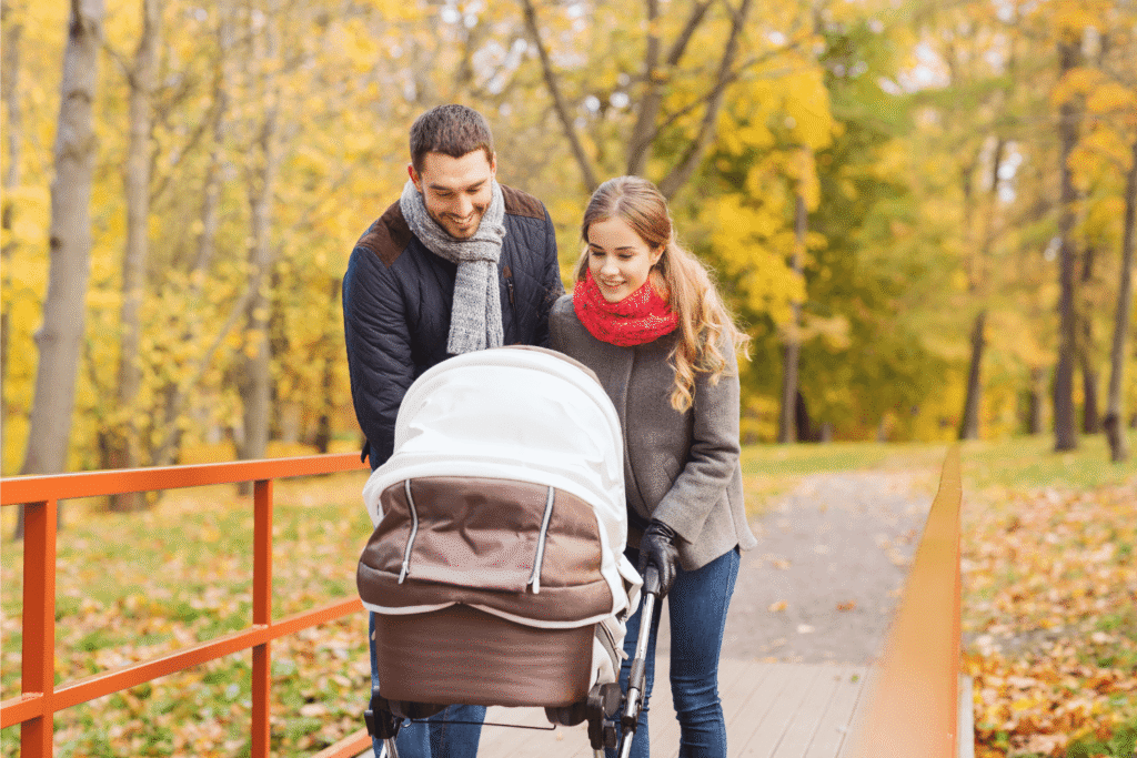adoptive parents pushing their baby in a stroller