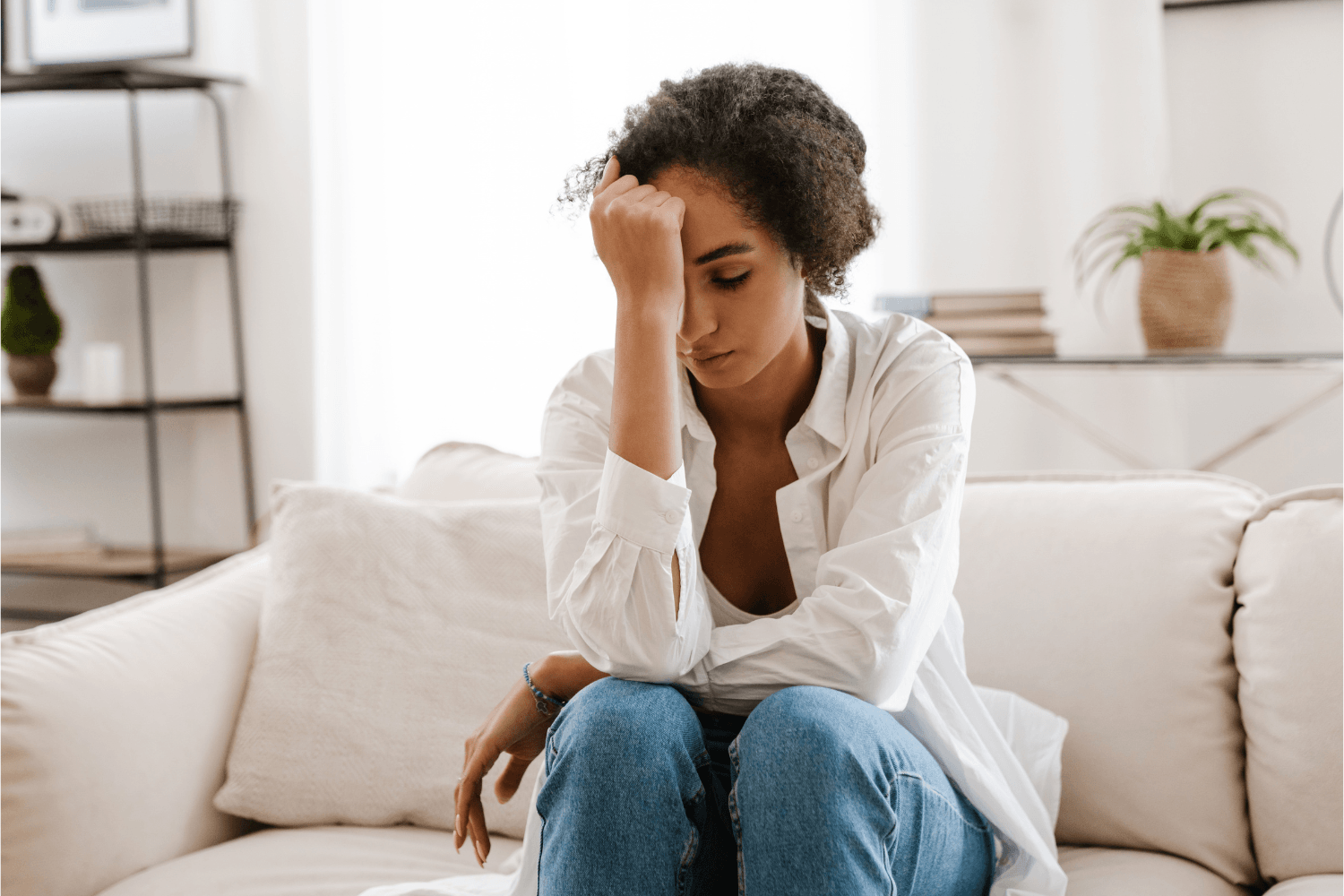 Woman in distress, holding her head in her hand