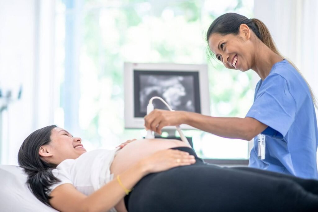 Nurse smiling at pregnant patient as she's giving her an ultrasound