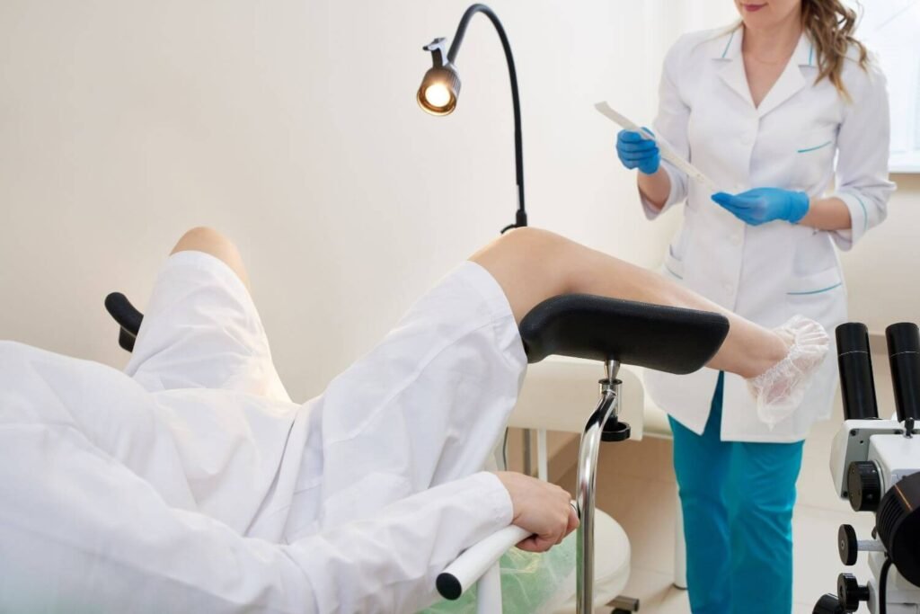 A gynecologist standing in front of a patient as she prepares STD testing supplies during an office visit